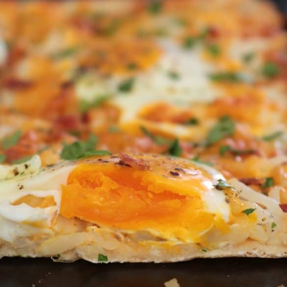 Breakfast Pizza topped with Eggs.