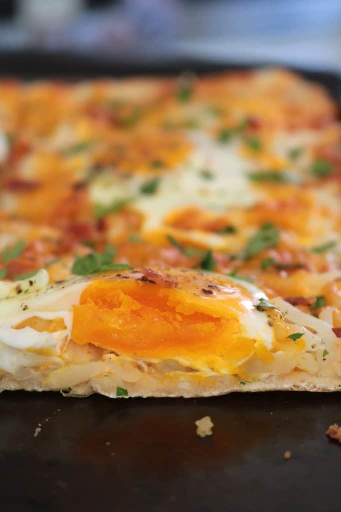 Breakfast Pizza topped with Eggs.