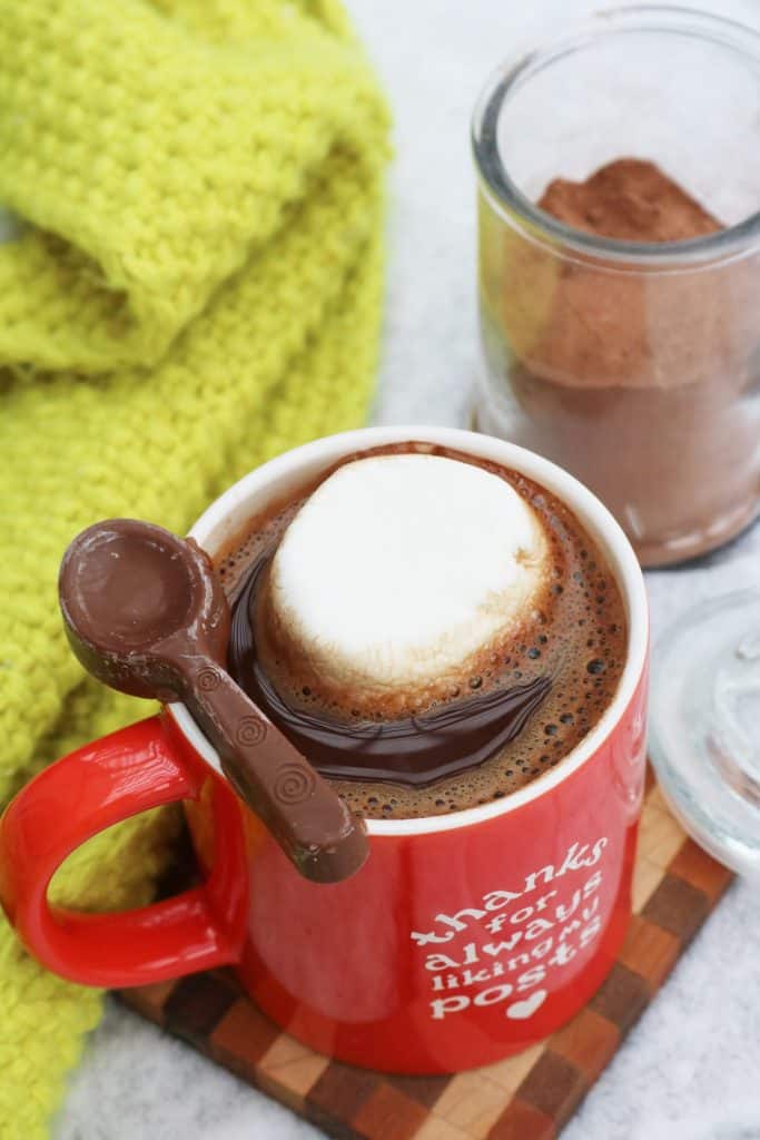 Prepared Salted Caramel Hot Cocoa in a mug with the mix in a jar behind it.