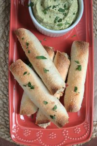 Baked Chicken Bacon Ranch Taquitos on a platter with Avocado Ranch.