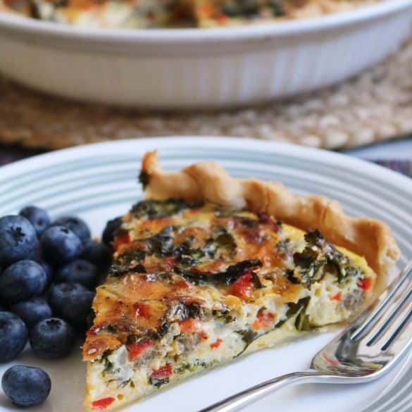 Kale Quiche - slice on a plate with blueberries.