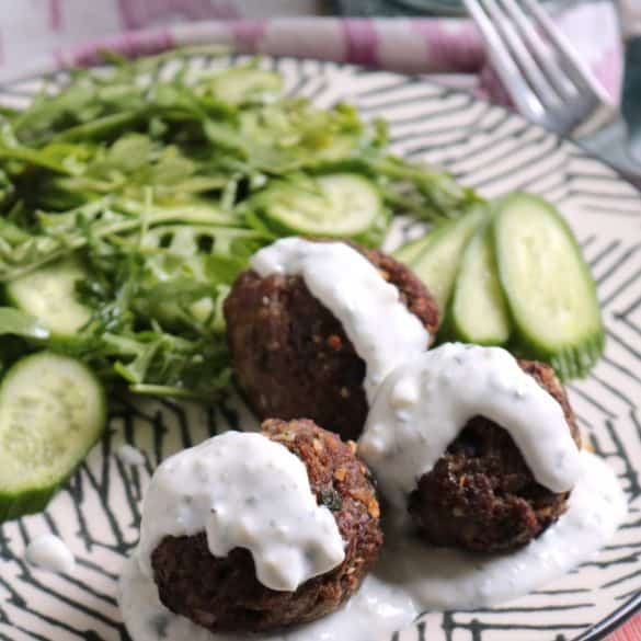 Mini Greek Meatloaves on a plate with a salad.