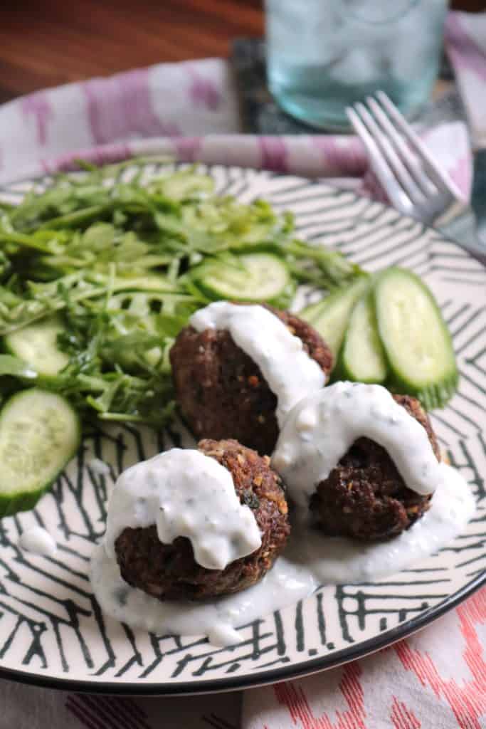 Mini Greek Meatloaves on a plate with a salad.