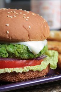 Spicy Edamame Burgers with cheese, tomato, red onion, and lettuce.