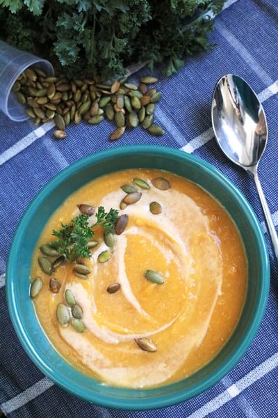 Slow Cooker Butternut Squash Soup topped with heavy cream swirl and toasted pepitas