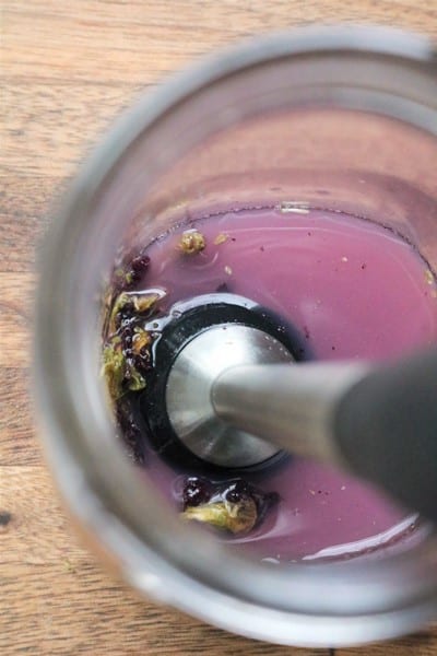 Muddling butterfly pea flowers in lemon juice