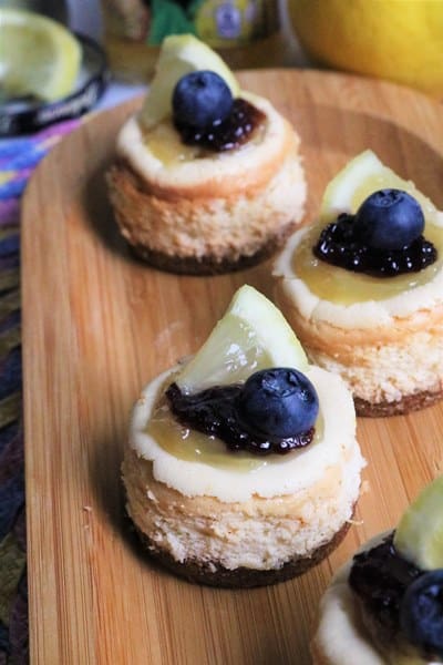 Lemon Ricotta Mini Cheesecakes topped with lemon curd and blueberry jam