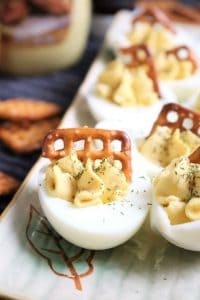 Honey Mustard Deviled Eggs with Pretzel and Dill Garnish.