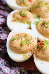Deviled Eggs made with Sriracha, topped with green onion.