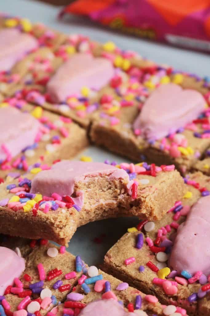 Close-up of bite taken out of Reese's Heart Peanut Butter Cup Cookie Bars.