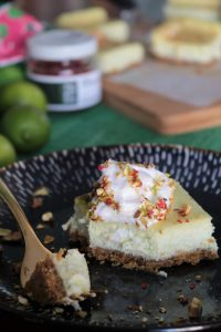 Key Lime Pistachio Cheesecake Bars, on a plate being eaten with a fork.