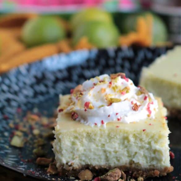 Key Lime Pistachio Cheesecake Bars Topped with Whipped Cream.
