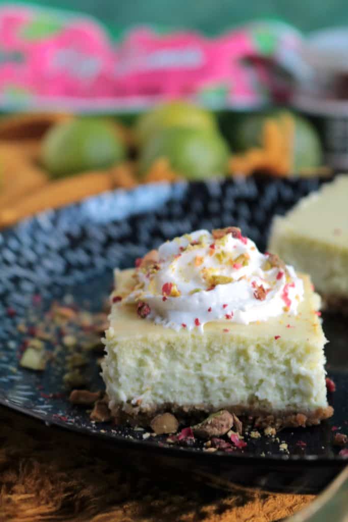 Key Lime Pistachio Cheesecake Bars Topped with Whipped Cream.