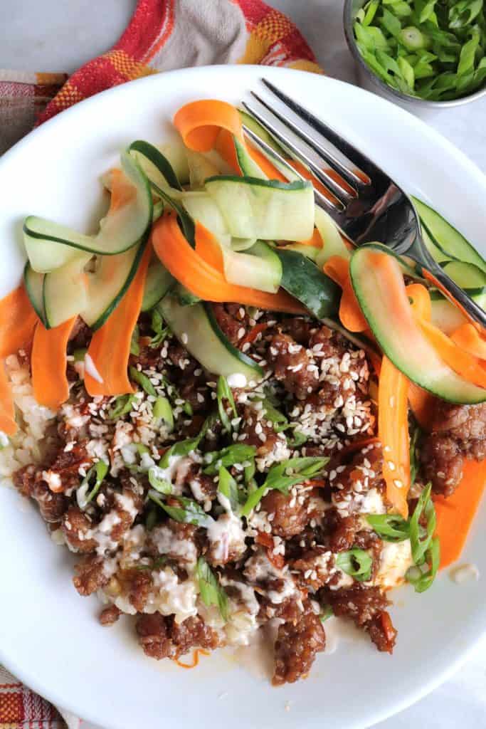 Pork Bulgogi Rice Bowls with Sriracha Cream and Pickled Carrots and Cucumber.