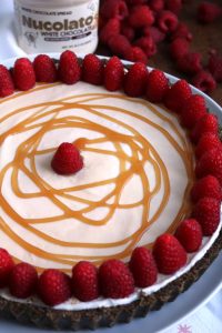 No Bake White Chocolate Pit topped with Caramel and Raspberries.