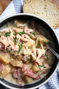 Reuben Soup topped with Dressing and Swiss cheese.